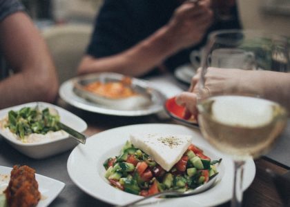 A beautifully arranged dinner setting featuring fresh salad and white wine, perfect for a fine dining experience.